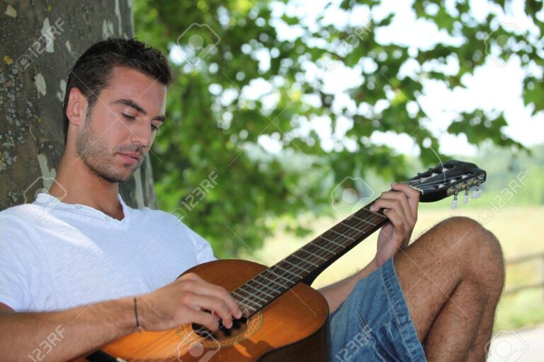 guitarrista tocando bajo un arbol
