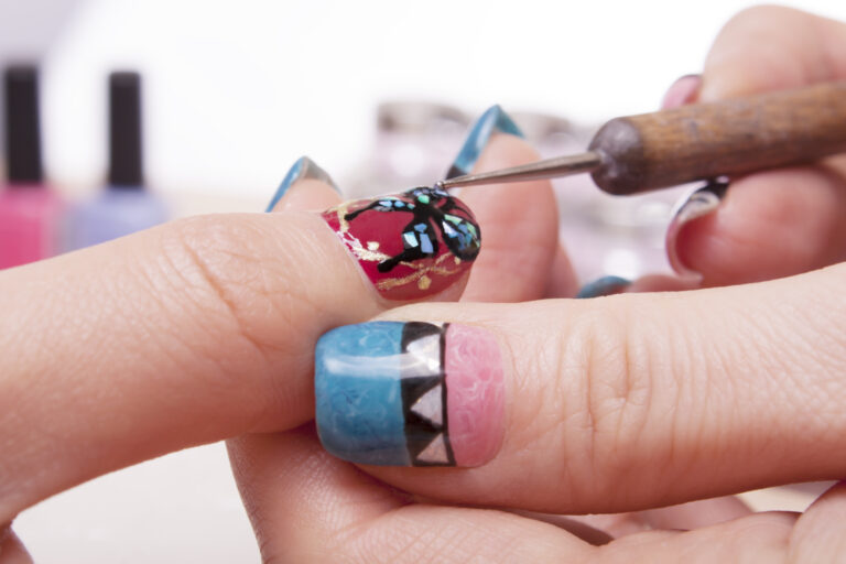 manos con unas decoradas y herramientas