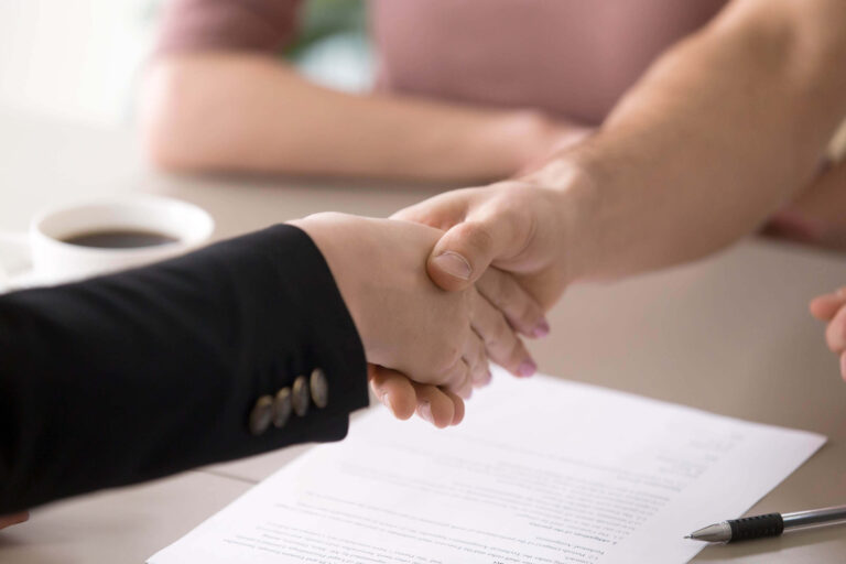 manos firmando un contrato laboral