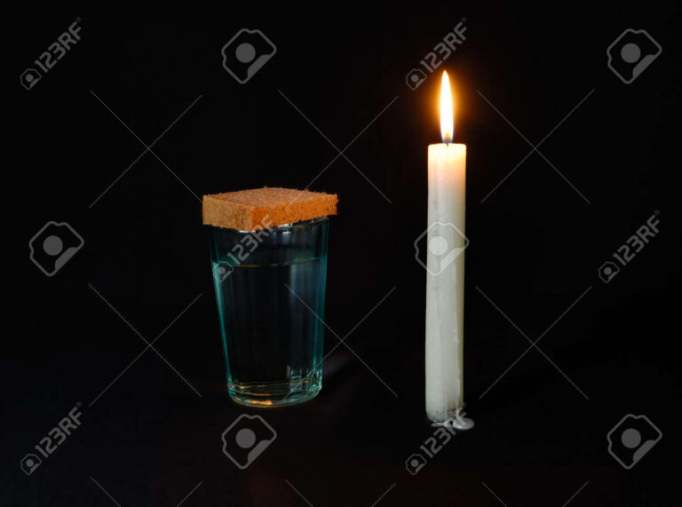 vaso de agua junto a una vela roja